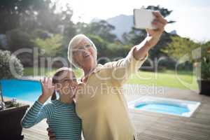 Granddaughter and grandmother taking a selfie near the pool