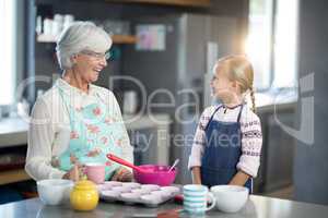 Smiling grandmother and granddaughter looking at each other