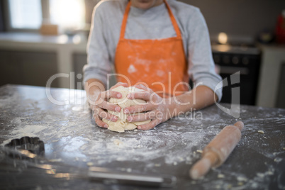 Little girl holding dough in her hand