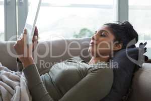 Woman using tablet on sofa