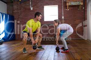 Trainer assisting teenage girl in exercise
