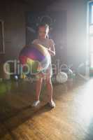 Girl holding colorful ball in living room