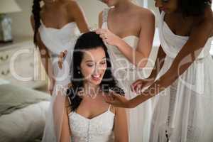 Bridesmaid assisting bride in getting ready