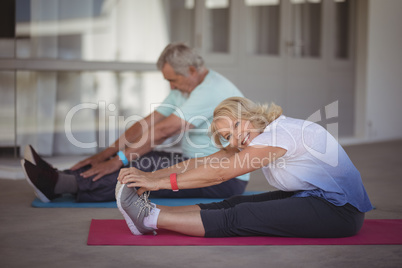 Senior couple performing stretching exercise