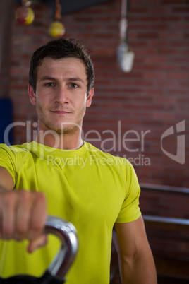 Portrait of confident man holding kettlebell