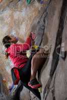 Determined woman practicing rock climbing