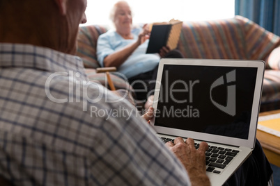 Senior man uisng laptop in nursing home