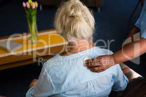Hand of nurse examining patient in retirement home