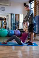 Physiotherapist assisting senior woman in exercise