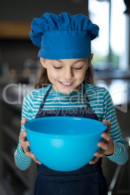 Smiling girl looking into the bowl in the kitchen