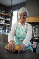 Senior woman having tart in kitchen