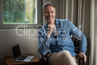 Smiling man sitting on chair in living room