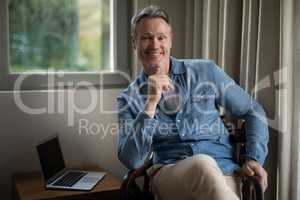 Smiling man sitting on chair in living room