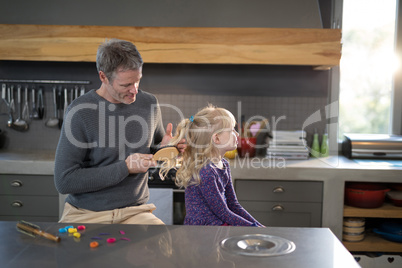 Father brushing daughters hair