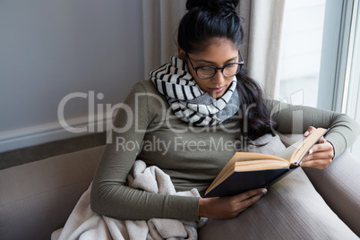 Woman reading book on sofa