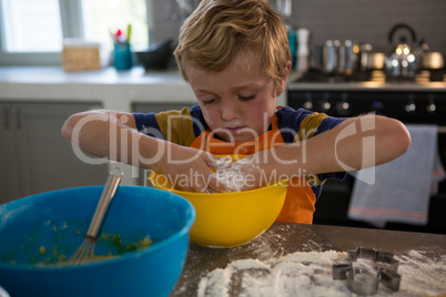 Boy mixing dough in yellow bowl