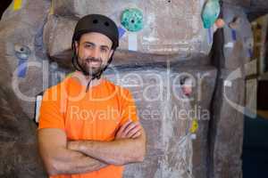 Trainer standing with arms crossed in fitness studio