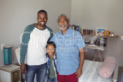 Smiling multi-generation family standing together in bedroom