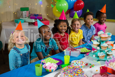 Portrait of children sitting at table