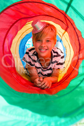 Portrait of boy lying in tent tunnel