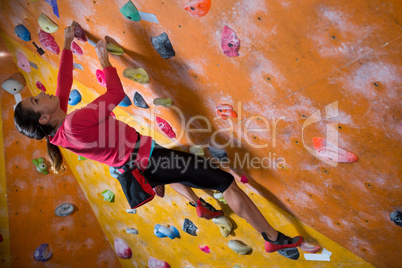 Determined woman practicing rock climbing