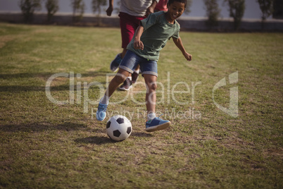 Boy playing football with his father and grandson