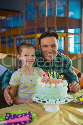 Father and daughter with birthday cake at home
