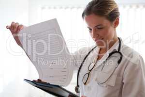 Female doctor examining reports in nursing home