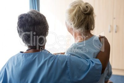 Rear view of nurse standing with senior woman