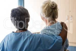 Rear view of nurse standing with senior woman