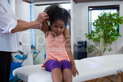 Physiotherapist giving hand massage to a girl