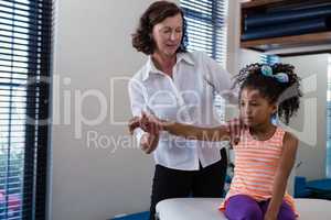 Physiotherapist giving hand massage to a girl