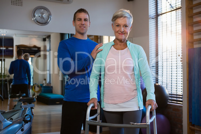 Portrait of physiotherapist and patient on walking frame