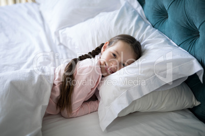 Smiling girl lying on bed in bedroom