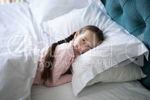Smiling girl lying on bed in bedroom