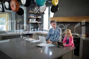 Father looking at daughter while using a tablet