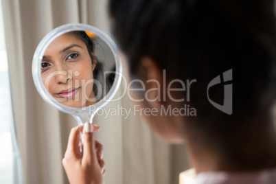 Woman reflecting on hand mirror