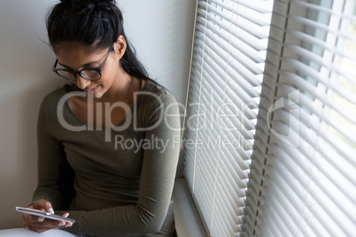 Woman using phone by window