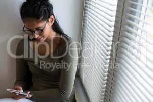 Woman using phone by window