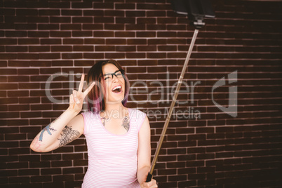 Smiling woman taking selfie from selfie stick