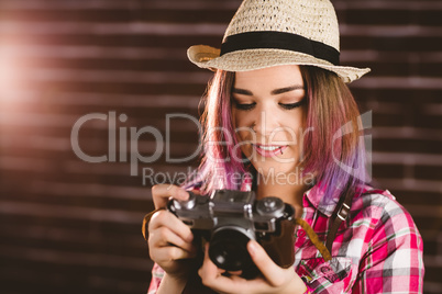 Smiling woman checking photos from vintage camera