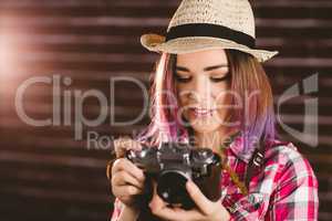 Smiling woman checking photos from vintage camera