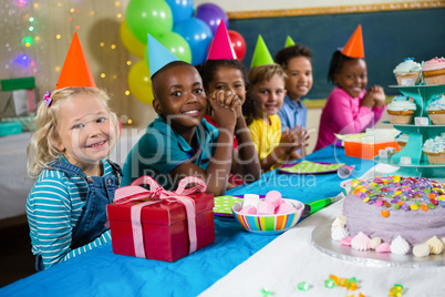 Portrait of children sitting at table during party