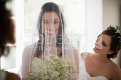 Bride standing with flower bouquet at home