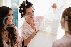 Smiling women looking at wedding dress