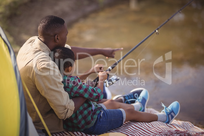 Father and son fishing together in park