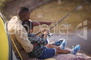 Father and son fishing together in park