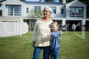 Granddaughter pointing at distance while grandmother standing beside her