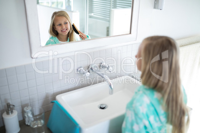 Girl combing her hair in bathroom