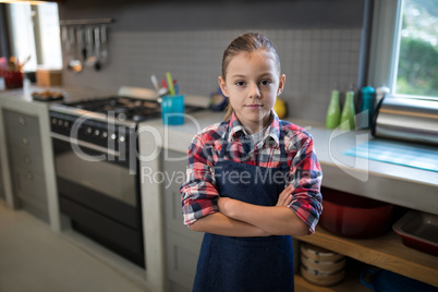 Smiling girl posing wearing an apron in the kitchen